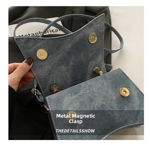 Detail of the golden magnetic clasp closure on a blue denim hourglass crossbody bag