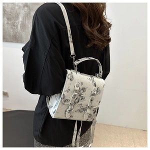 Detail of white cross-body bag featuring black butterfly and celestial star prints