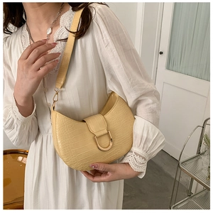 Detail of yellow crocodile embossed leather underarm bag with gold D-ring buckle accessory