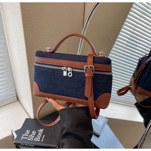 Detail view of denim and brown pebbled leather patchwork on a mini square satchel