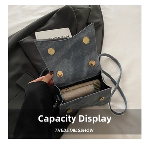 Detail view of denim blue shoulder bag interior capacity with magnetic snap closures