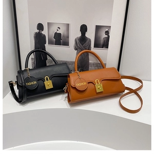 Detail shot of black and brown vintage crossbody bags with gold buckles and fashion pendants