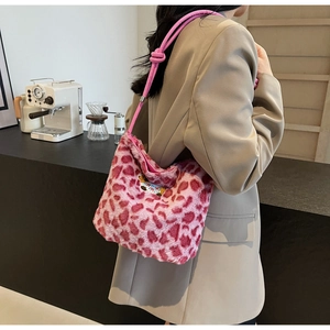 Sac seau en peluche rose à imprimé léopard avec broderie ours porté par un mannequin