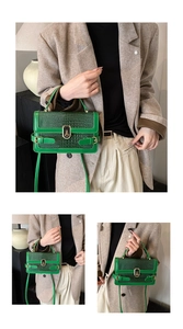 Detail of green crocodile embossed PU leather crossbody bag with gold buckle hardware