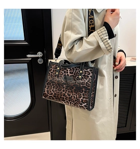 Detail of leopard print tote bag featuring a detachable wide strap and golden buckles