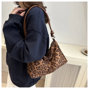 Dettaglio della borsa tote leopardata con tracolla in pelle marrone e nodo decorativo