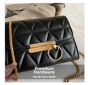 Macro view of black quilted leather with triangle stitching and golden hardware details