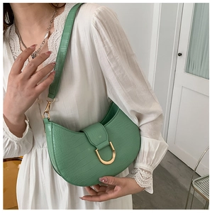 Detailed texture of mint green faux leather bag with crocodile pattern and golden buckle