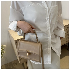 Dettaglio borsa beige in ecopelle con chiusura dorata e tracolla sottile regolabile