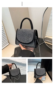 Detail of black handbag with sparkling rhinestones and silver metal chain strap