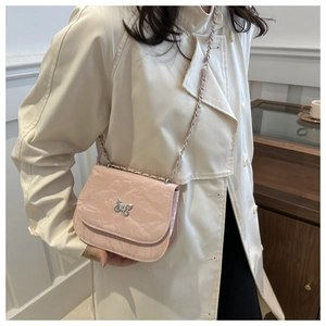 Pink chain crossbody bag with textured fabric and silver butterfly buckle detail