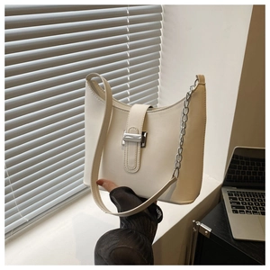 Detail of cream white half-moon bag with silver metal buckle and adjustable strap
