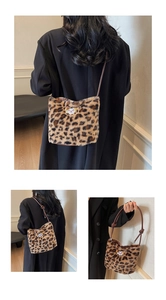 Detailed close-up of plush leopard print bucket bag with embroidery and tied leather strap