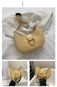 Detail of yellow crocodile pattern underarm bag with pearl chain and D-shaped metal buckle