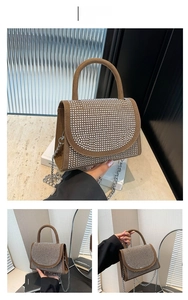 Detail of brown suede crossbody bag with sparkling rhinestones and metal chain strap