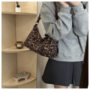 Detail of leopard print shoulder bag with knotted strap and retro zipper closure