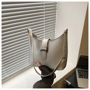 Close-up of silver trapezoid handbag with metallic finish and chain strap details
