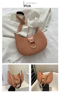 Detail of pink croc-effect crescent bag with pearl strap and golden U-shaped buckle