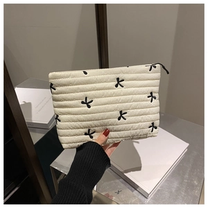 Détail de la trousse de maquillage en velours côtelé blanc avec broderie papillon et zip