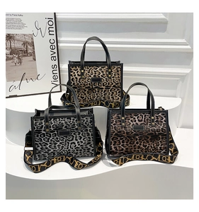Detail of leopard print tote bags with leather handles and gold rivet accents