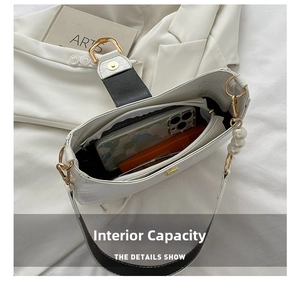 Internal view of white croc-embossed shoulder bag with pearl strap and gold hardware