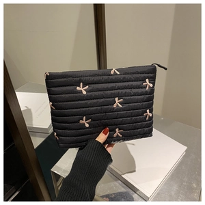 Détail de la pochette noire en velours côtelé avec broderie nœud rose et fermeture éclair