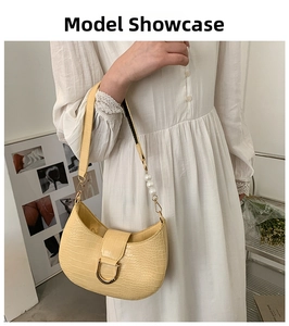 Detail of yellow crocodile pattern handbag with pearl strap and golden buckle accent