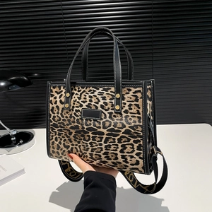 Large leopard print tote bag with black trim and wide shoulder strap for autumn fashion