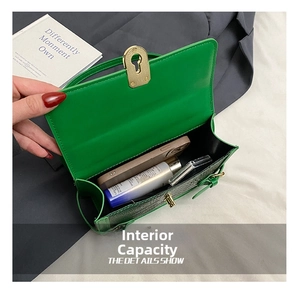 Detail of green crocodile pattern handbag showing interior capacity with gold clasp
