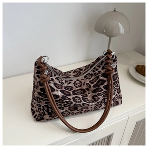 Macro detail of leopard print shoulder bag featuring brown knotted straps and silver hardware