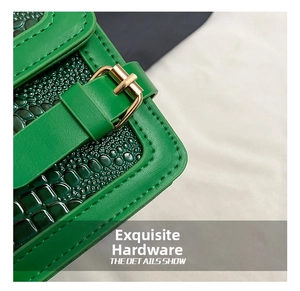 Close-up of green crocodile embossed faux leather with premium gold metal buckle detail