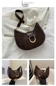 Detail of brown crocodile pattern saddle bag with pearl chain and golden U-buckle
