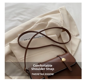 Detail of comfortable brown leather shoulder strap and golden buttons on crossbody bag