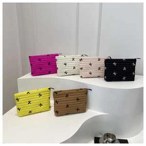 Detailed close-up of quilted makeup bags with floral embroidery in six vibrant colors