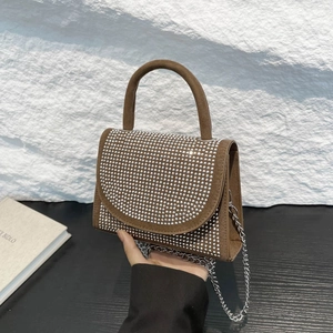 Brown suede handbag with silver rhinestones and metal chain strap held by model