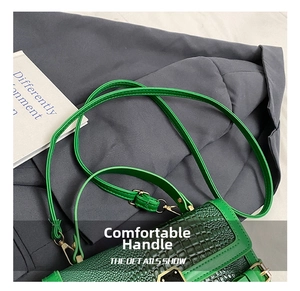 Detail shot of green crocodile pattern PU leather surface with gold metal clasp buckle