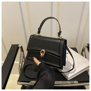 Dettaglio borsa a tracolla in pelle nera con elegante chiusura ad anello d'oro