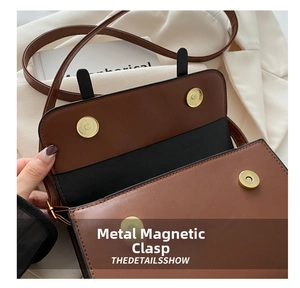 Detail showing the golden double magnetic snap closure on the caramel crossbody bag
