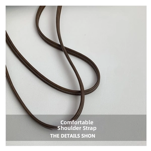 Detailed macro view of high-quality dark brown leather round cord shoulder strap
