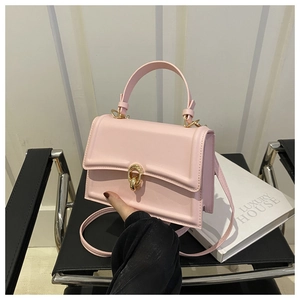 Dettaglio borsa a tracolla in pelle opaca rosa con chiusura magnetica a doppio anello d'oro