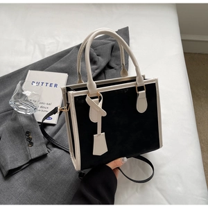 Detail of minimalist black and white contrast tote bag with premium metal hardware