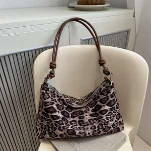 Borsa tote retrò leopardata con tracolla a corda annodata su sedia bianca
