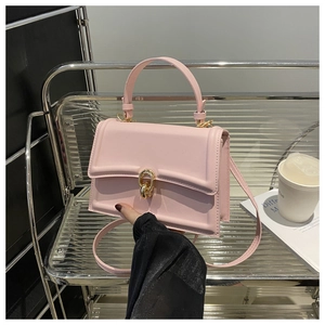 Dettaglio della borsa a tracolla in pelle rosa chiaro con chiusura ad anello e manico