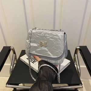 Silver retro saddle bag with crinkled texture and metal butterfly buckle on a chain strap