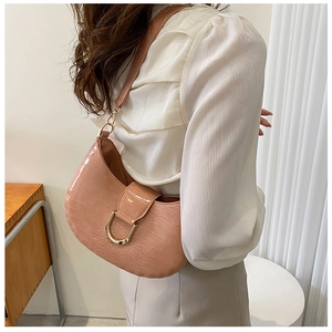 Detail of salmon pink faux crocodile leather shoulder bag with golden U-shaped buckle