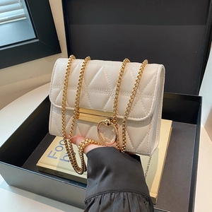 White quilted flap bag with triangle patterns and a thick gold chain strap in a gift box