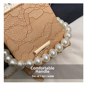 Detail of lace texture and pearl handle on light brown chic crossbody small bag