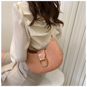 Model wearing pink crocodile pattern hobo bag with gold buckle detail shown from the back