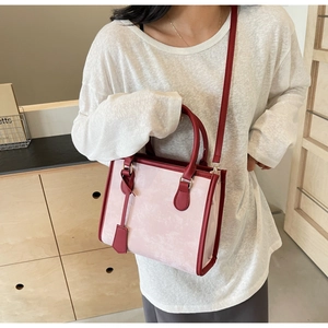 Vista dettagliata della borsa tote rosa marmorizzata indossata con tracolla a contrasto