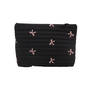 Quilted black makeup bag with pink embroidered bows and zipper closure for women